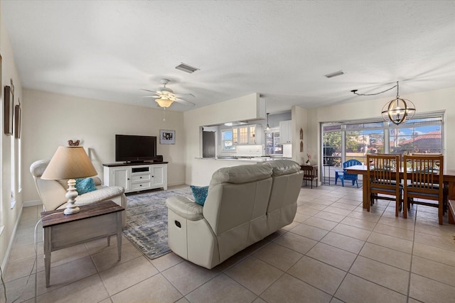 living room featuring light tile patterned floors and ceiling fan with notable chandelier