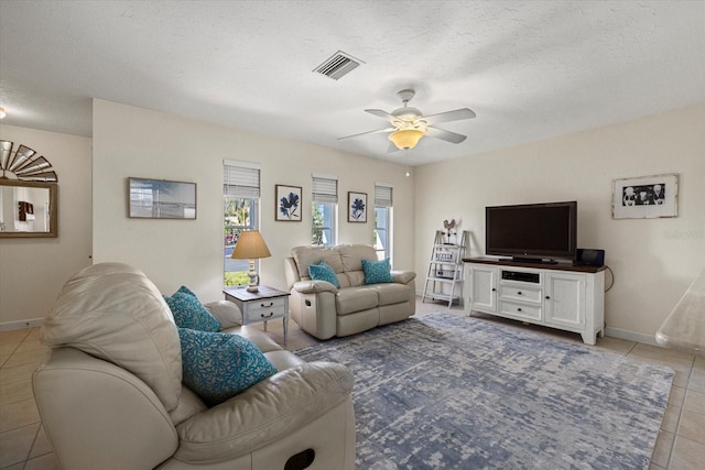 living room featuring a textured ceiling, tile patterned floors, and ceiling fan