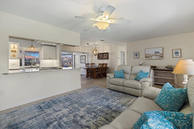 living room with ceiling fan with notable chandelier and light tile patterned floors