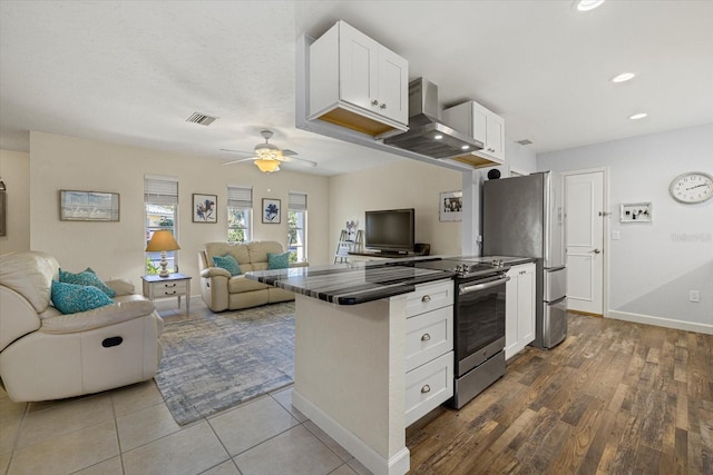 kitchen with appliances with stainless steel finishes, ventilation hood, ceiling fan, wood-type flooring, and white cabinetry