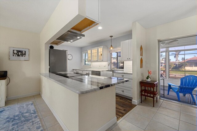 kitchen featuring white cabinets, a wealth of natural light, kitchen peninsula, and appliances with stainless steel finishes