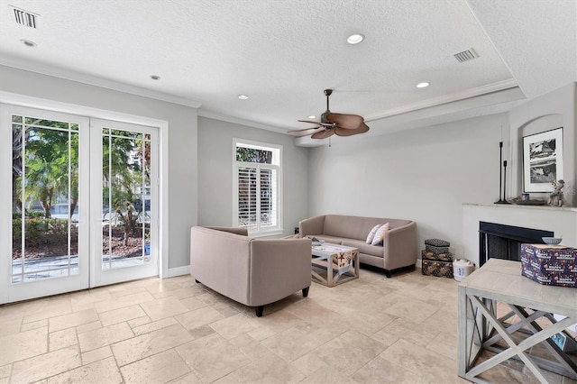 living room featuring ceiling fan, crown molding, and a textured ceiling