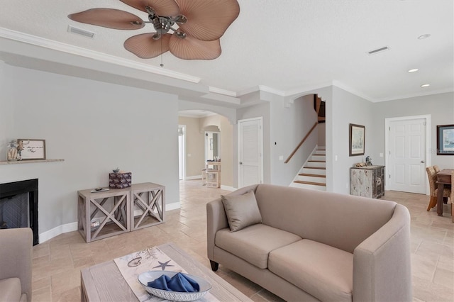 living room with crown molding, ceiling fan, and a textured ceiling