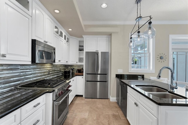 kitchen with sink, white cabinets, decorative light fixtures, and appliances with stainless steel finishes