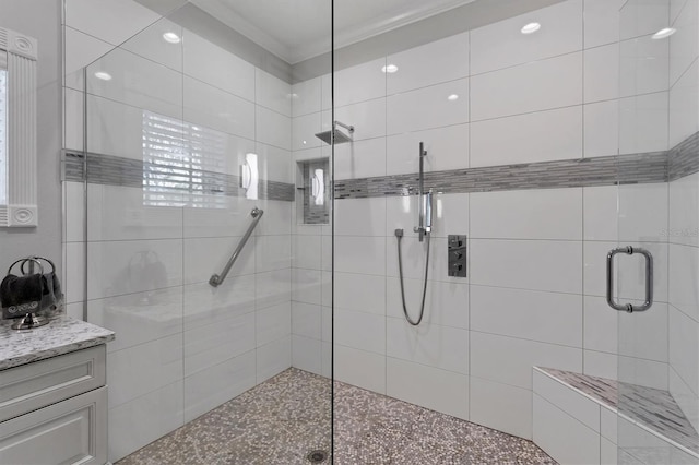 bathroom with vanity, an enclosed shower, and crown molding