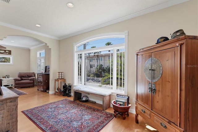 entrance foyer featuring crown molding and light wood-type flooring