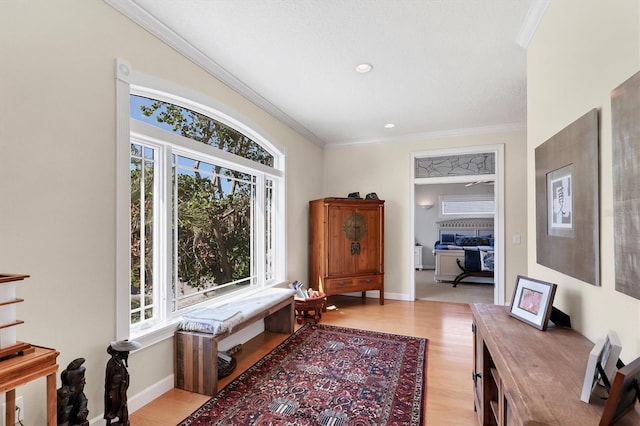 sitting room featuring ornamental molding, light wood-type flooring, and a healthy amount of sunlight