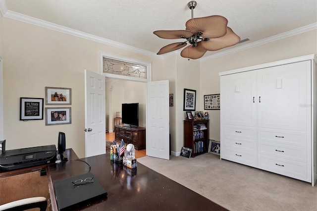 carpeted office with ceiling fan, ornamental molding, and a textured ceiling