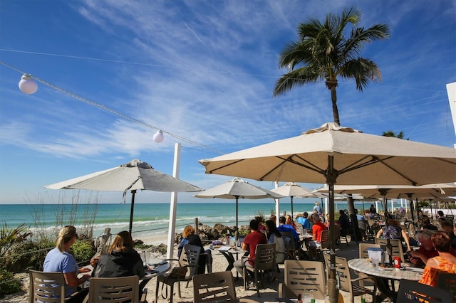 surrounding community with a water view and a view of the beach