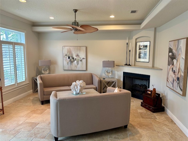 living area with baseboards, recessed lighting, ornamental molding, a textured ceiling, and a glass covered fireplace