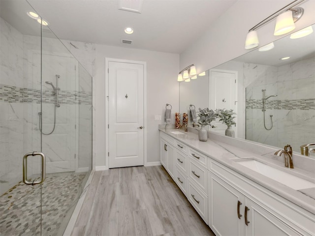 bathroom with hardwood / wood-style floors, vanity, and walk in shower