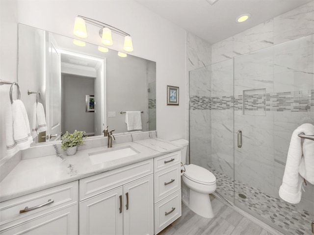 bathroom featuring toilet, vanity, and walk in shower