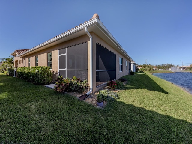 view of home's exterior featuring a yard and a water view