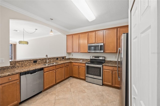 kitchen featuring dark stone countertops, crown molding, sink, and appliances with stainless steel finishes