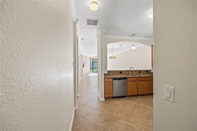 kitchen featuring dark stone counters, ornamental molding, sink, dishwasher, and light tile patterned flooring