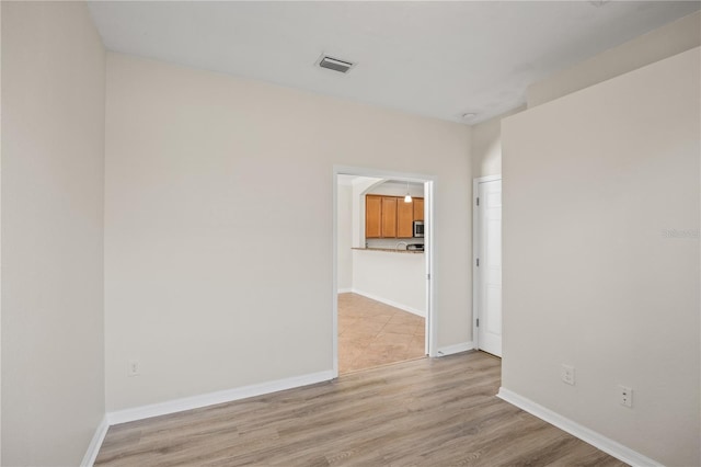 unfurnished room with light wood-type flooring