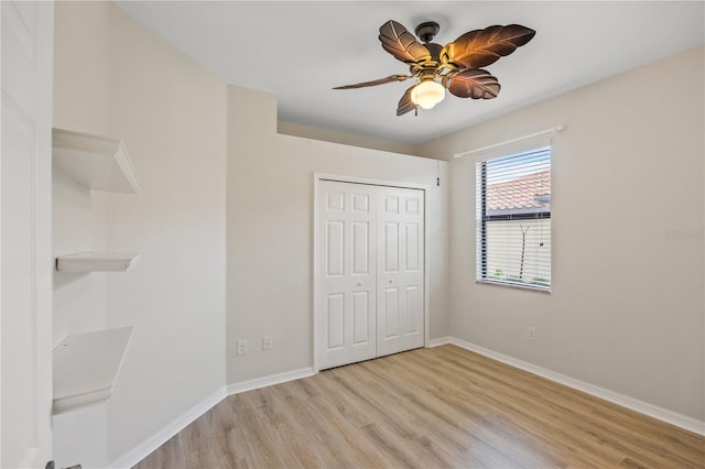 unfurnished bedroom with ceiling fan, light wood-type flooring, and a closet