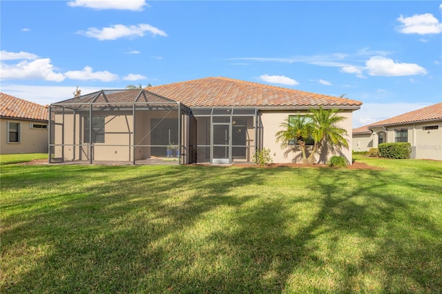 back of house with a lanai and a lawn