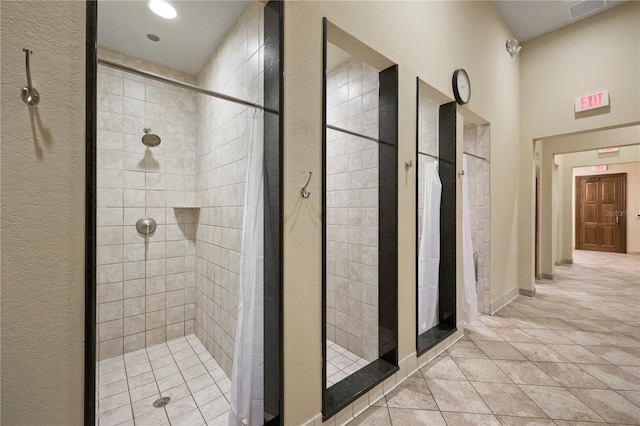 bathroom featuring a tile shower and tile patterned flooring