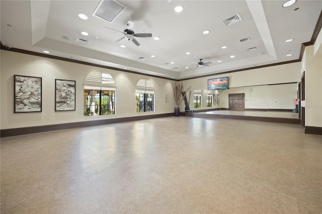 interior space with ceiling fan, a raised ceiling, and ornamental molding