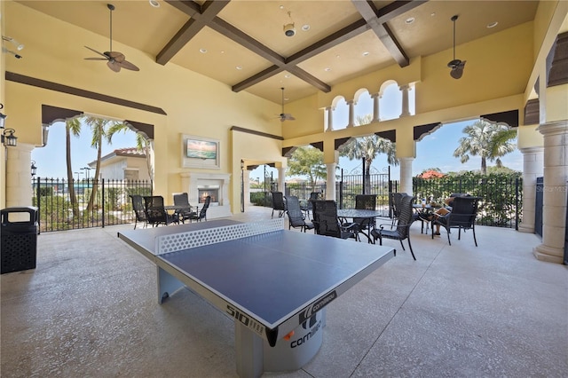 game room featuring beam ceiling, coffered ceiling, and a high ceiling