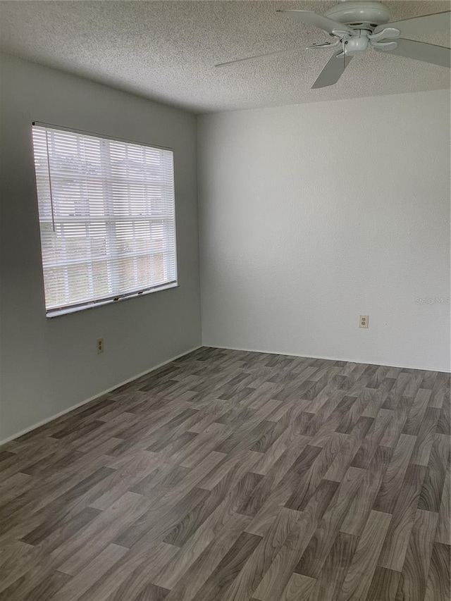 empty room featuring ceiling fan, dark hardwood / wood-style flooring, and a textured ceiling