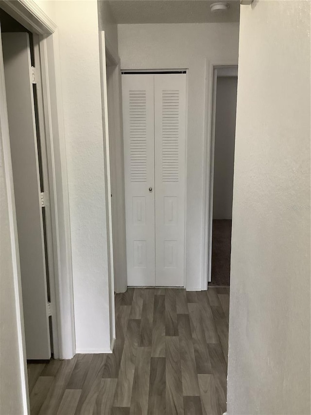 corridor with dark hardwood / wood-style flooring