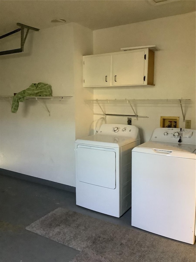 laundry room with washer and dryer and cabinets