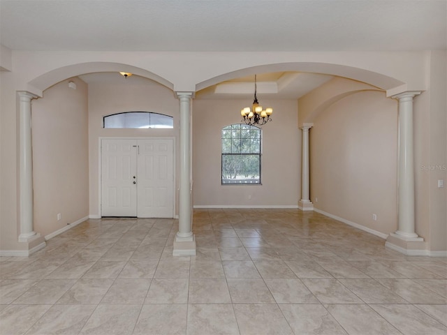 entrance foyer with a notable chandelier, light tile patterned floors, and a tray ceiling