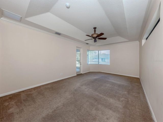 spare room with a raised ceiling, carpet flooring, and ornamental molding