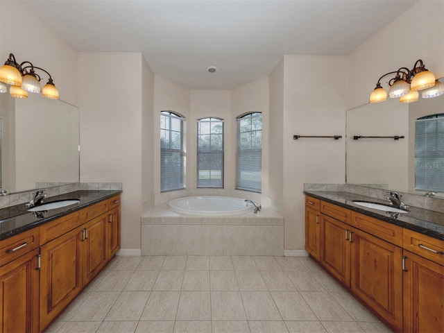 bathroom featuring tile patterned flooring, vanity, and tiled bath