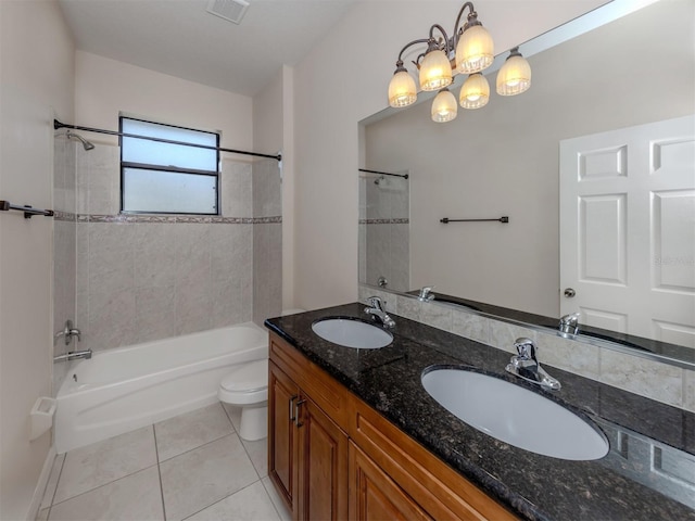 full bathroom with vanity, an inviting chandelier, tiled shower / bath, tile patterned flooring, and toilet