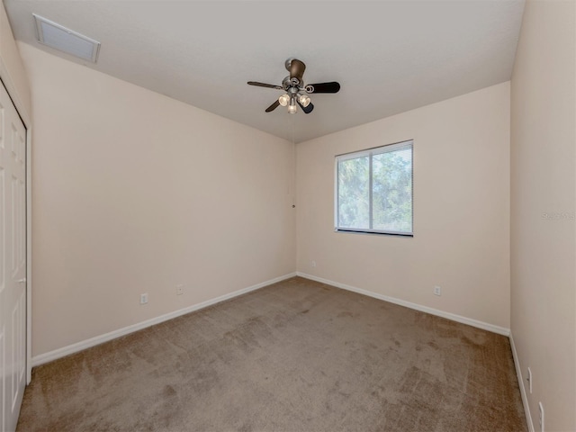 spare room featuring light carpet and ceiling fan