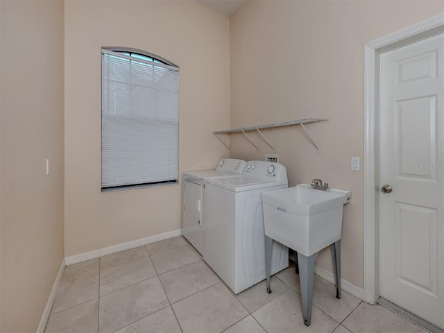 washroom with light tile patterned floors and washer and clothes dryer