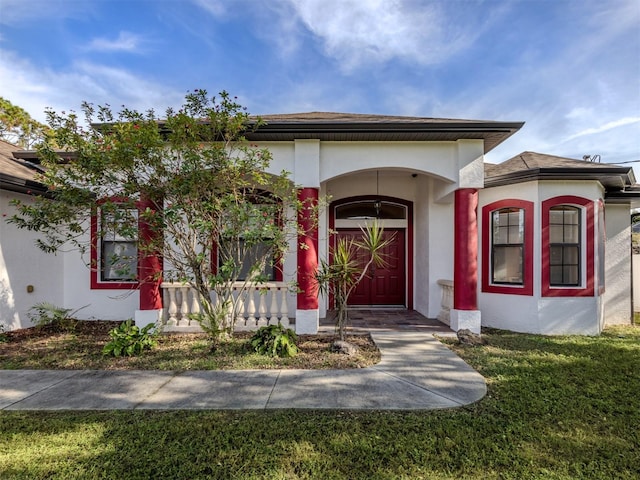 entrance to property with a yard and covered porch