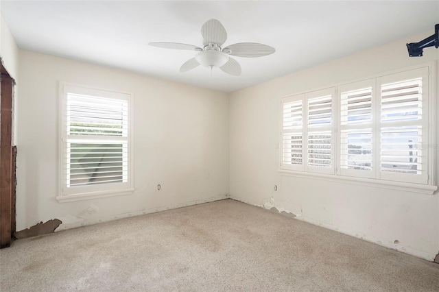 carpeted empty room with ceiling fan and a healthy amount of sunlight