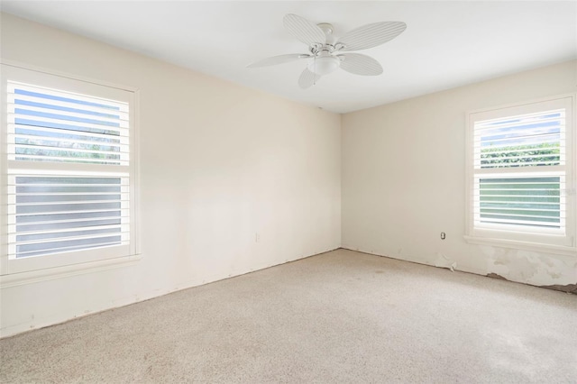 carpeted spare room featuring ceiling fan