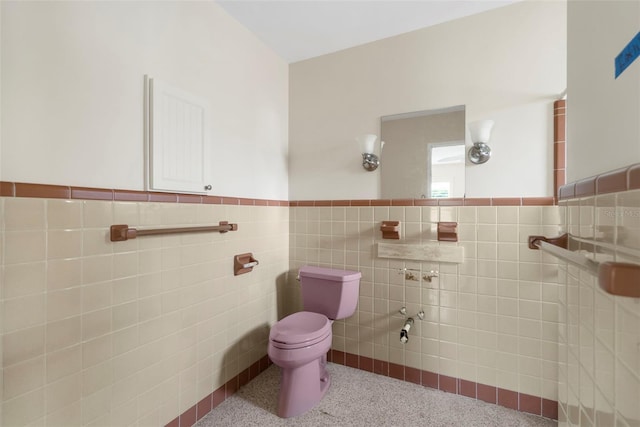 bathroom with toilet and tile walls