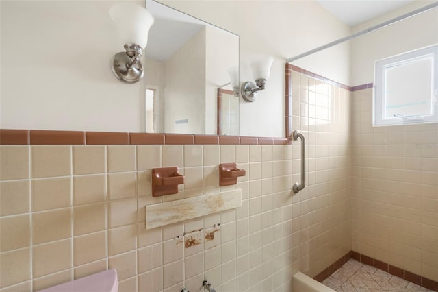 bathroom featuring tiled shower and tile walls