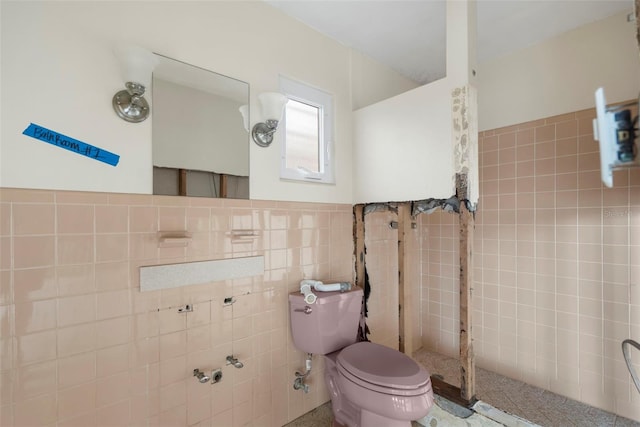 bathroom featuring toilet and tile walls