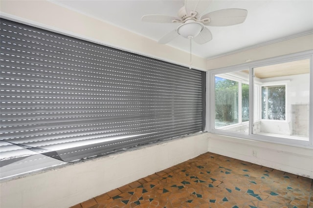 unfurnished sunroom with ceiling fan