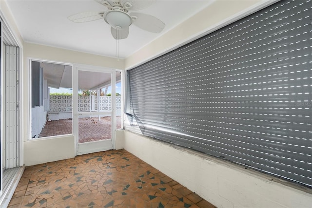 unfurnished sunroom featuring ceiling fan