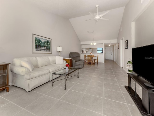 tiled living room with ceiling fan and high vaulted ceiling