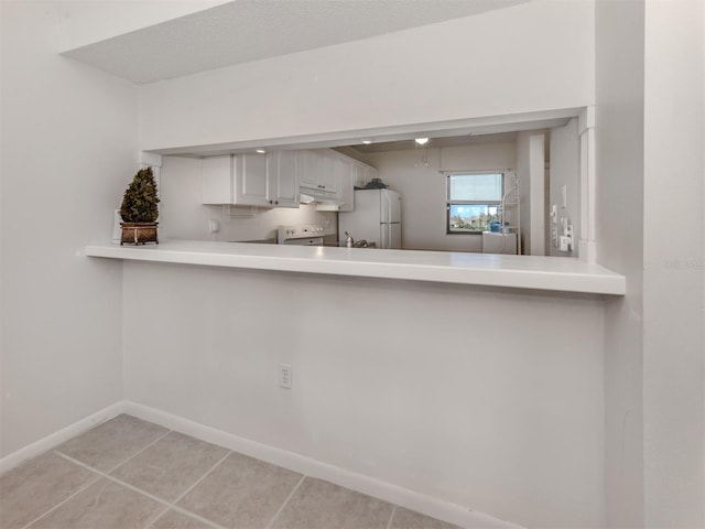 kitchen with white cabinets, light tile patterned flooring, and white appliances