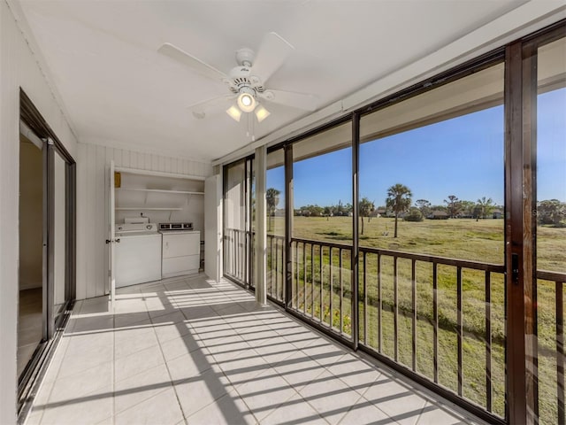 sunroom / solarium featuring separate washer and dryer, ceiling fan, and a rural view