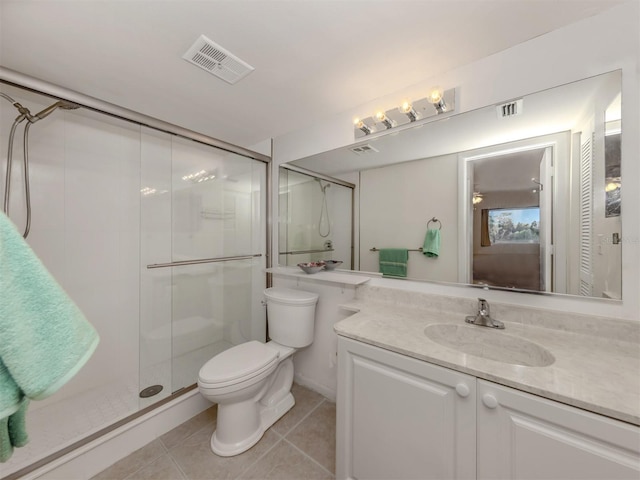 bathroom featuring tile patterned floors, vanity, toilet, and a shower with shower door