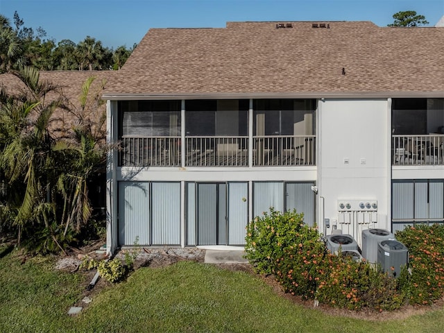 back of house featuring a yard and central air condition unit