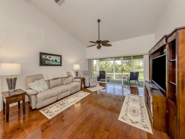 living room featuring dark hardwood / wood-style flooring, high vaulted ceiling, and ceiling fan