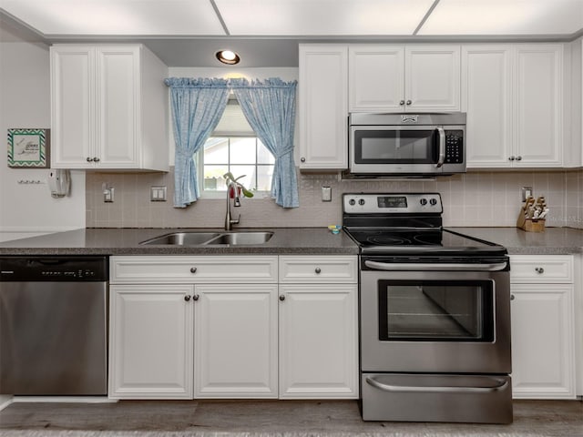 kitchen with white cabinets, sink, stainless steel appliances, and tasteful backsplash