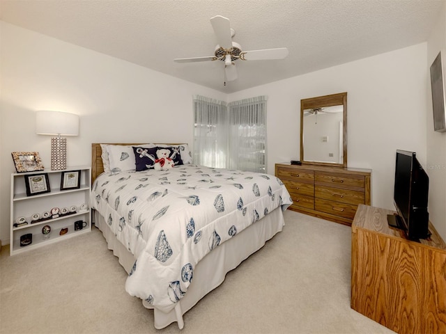 carpeted bedroom with ceiling fan and a textured ceiling